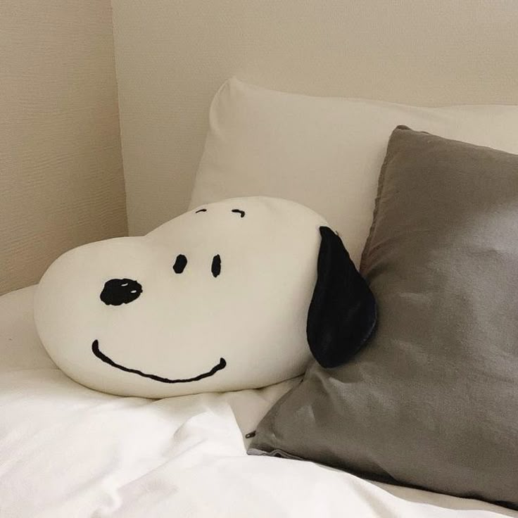 a pillow with a dog's face on it sitting on top of a bed