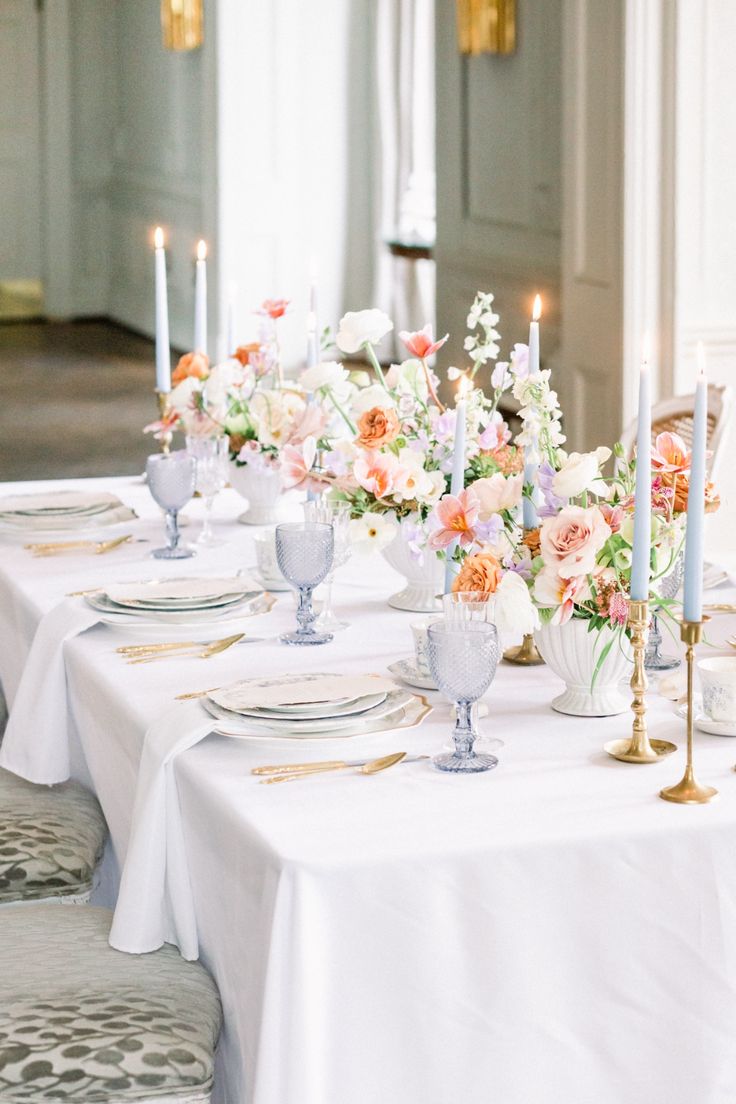 the table is set with flowers and candles