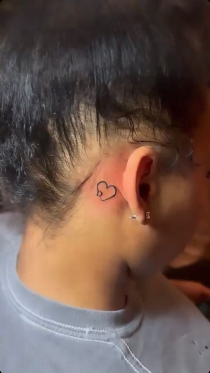 a woman with a small heart behind her ear