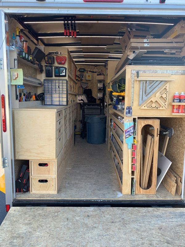 the inside of a van with many drawers and tools in it's back door