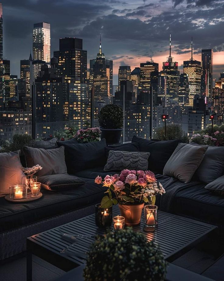 a living room filled with lots of furniture next to a cityscape at night