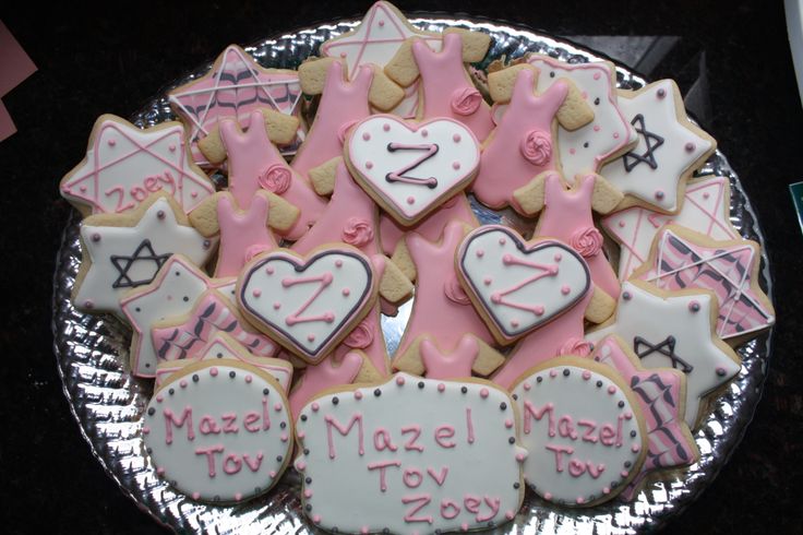 decorated cookies are arranged in the shape of letters and numbers on a platter with pink icing