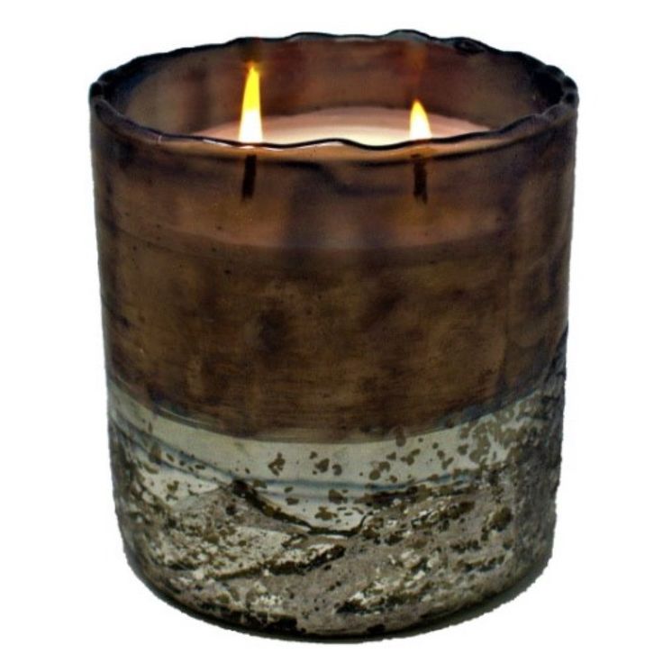 a candle that is sitting in the middle of a glass container with two candles inside