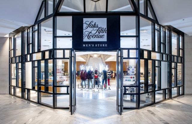 an entrance to a store with people walking in it