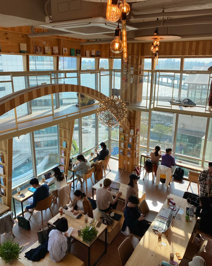 an overhead view of people sitting at tables in a large room with lots of windows