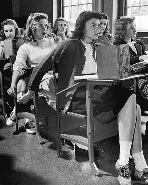 black and white photograph of people sitting at desks