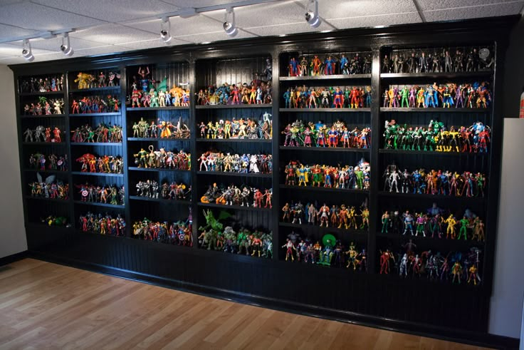 a room filled with lots of action figures on shelves next to a wall full of other action figures