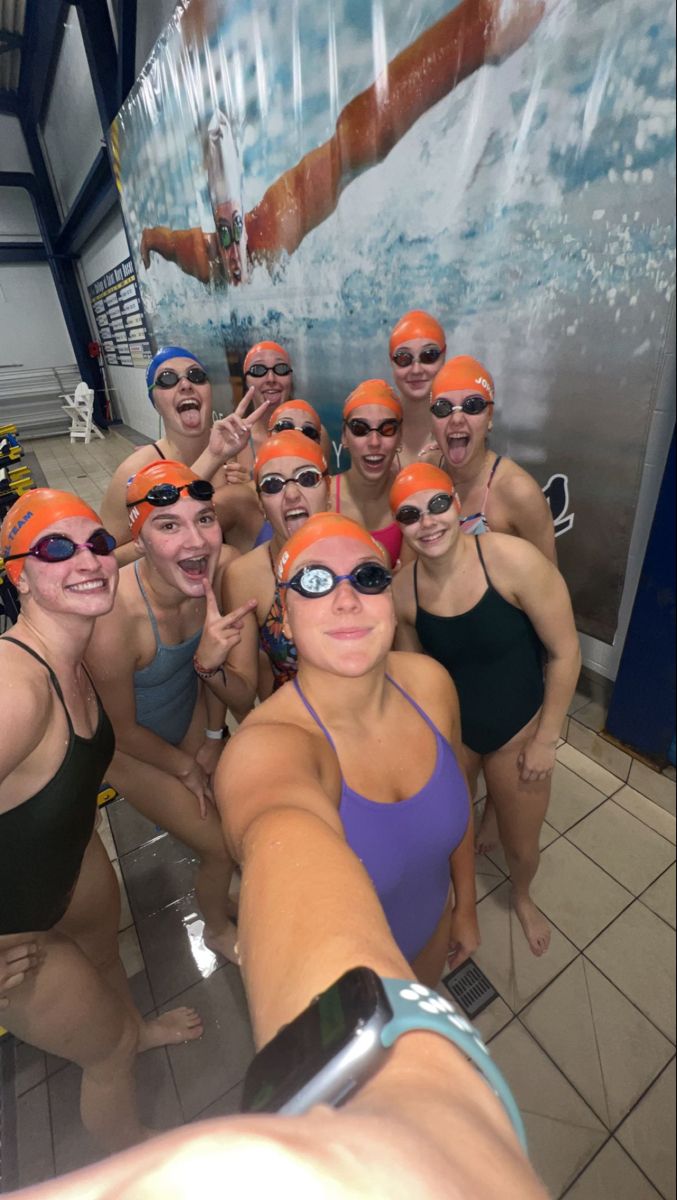 a group of women standing next to each other wearing swimming goggles