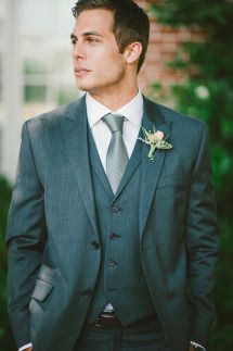 a man in a suit and tie standing outside