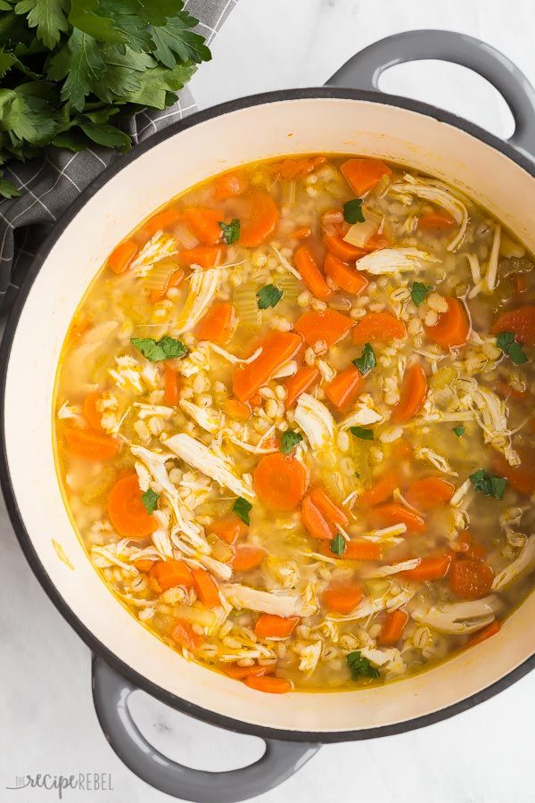 a pot filled with chicken and rice soup next to parsley on the counter top