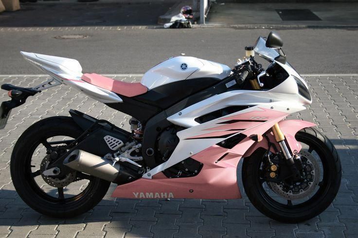 a pink and white motorcycle parked on the street