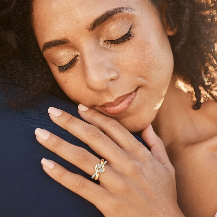 a close up of a person with a ring on their finger and her hand near her face