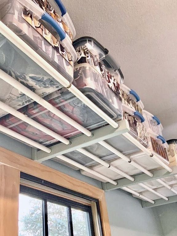 the shelves are filled with pots and pans on top of each other in front of a window