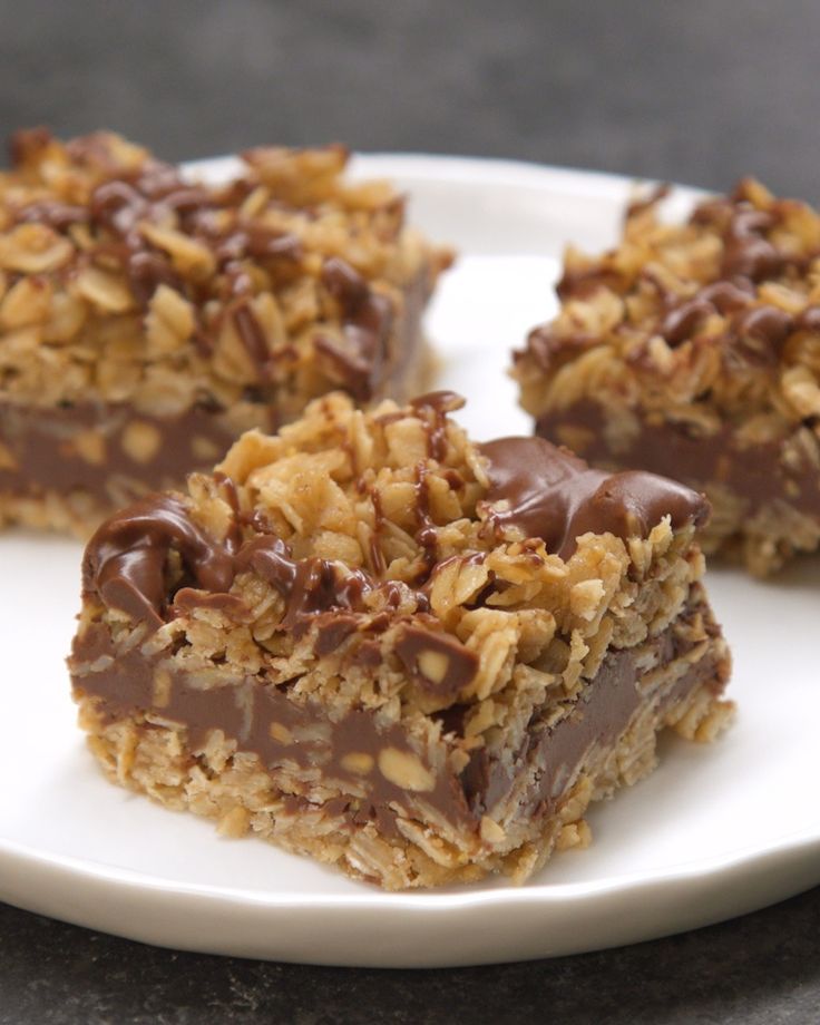 three pieces of chocolate covered granola bars on a plate