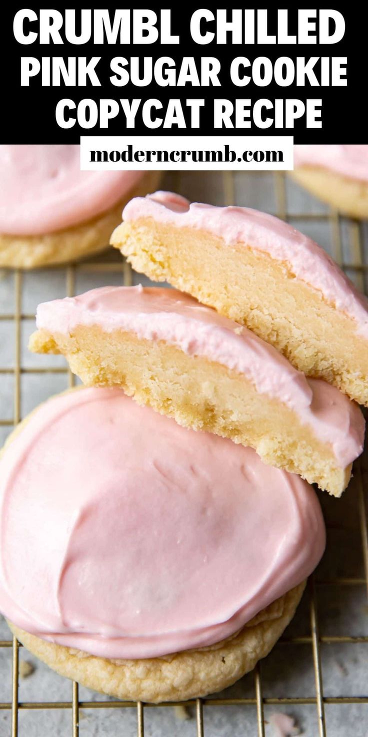 some cookies with pink icing on top of a cooling rack