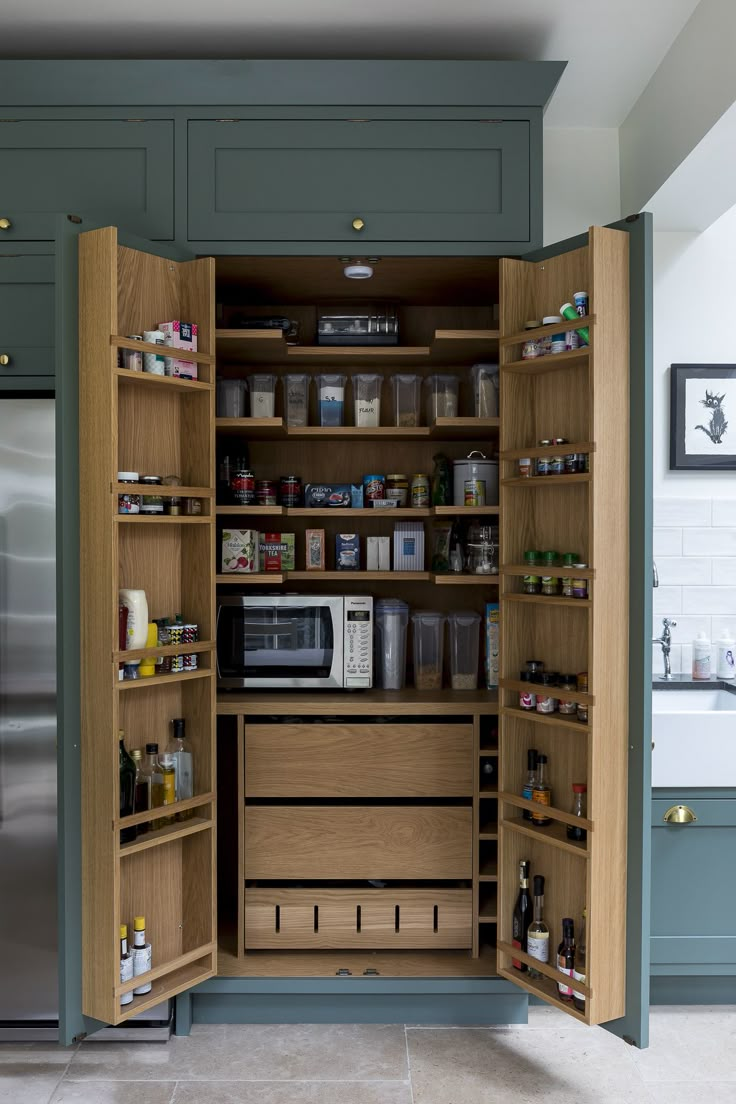 an open cabinet in the middle of a kitchen