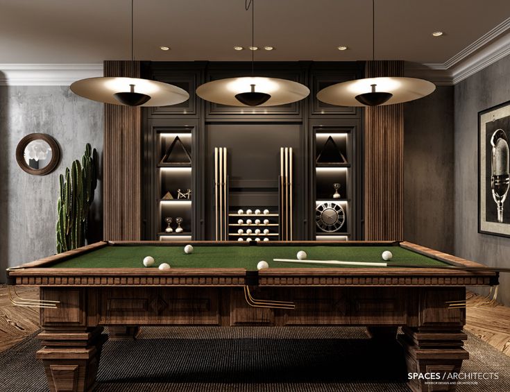 a pool table in the middle of a room with two lamps hanging from the ceiling