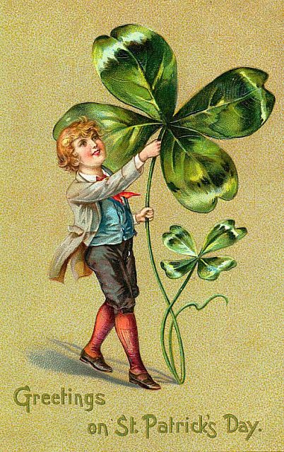 a young boy holding up a four leaf clover with the words greetings on st patrick's day