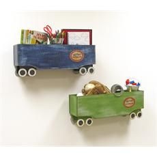 two wooden toy cars are on display against a white wall, one is green and the other is blue