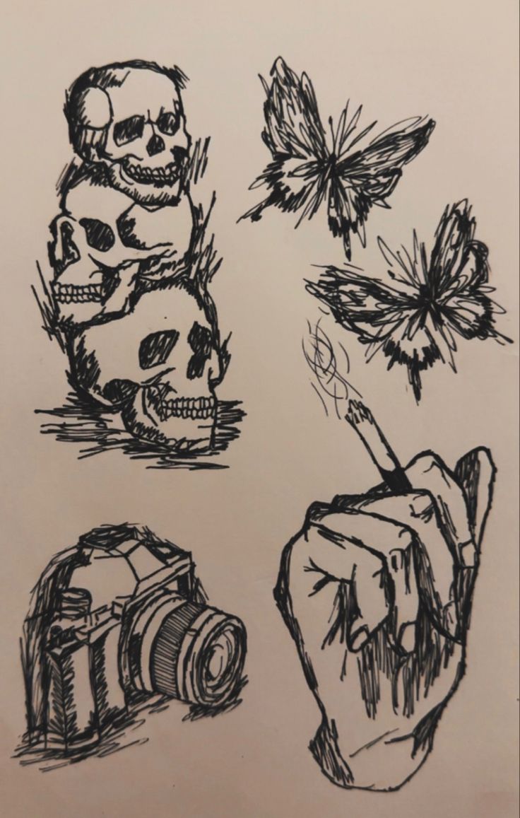 a drawing of skulls and flowers on a piece of paper with a hand holding a camera