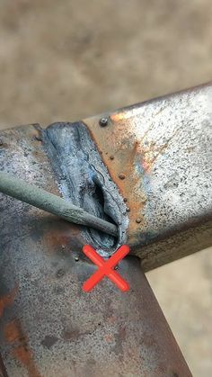 a piece of metal that has been bent over with a red cross on the end