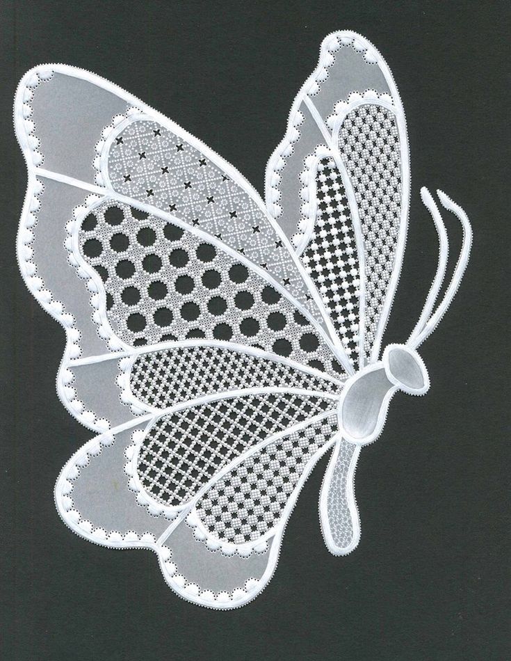 a white butterfly with black dots on it's wings is shown in the shape of a