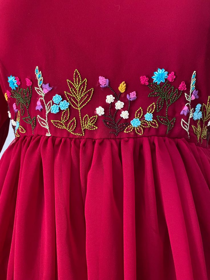 a woman wearing a red dress with flowers on it