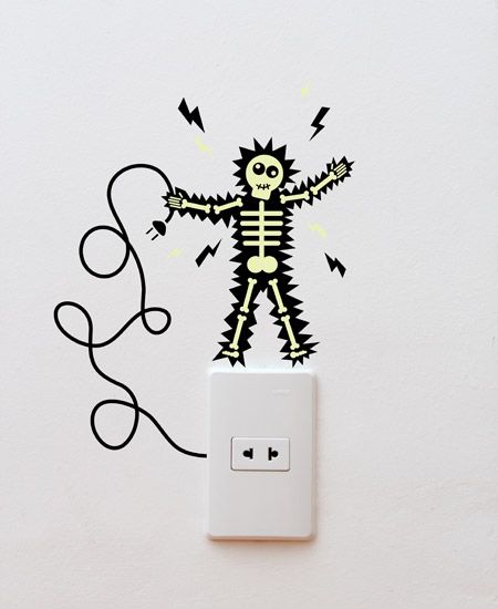 a wall mounted light switch with a skeleton sticker on it's face and arms