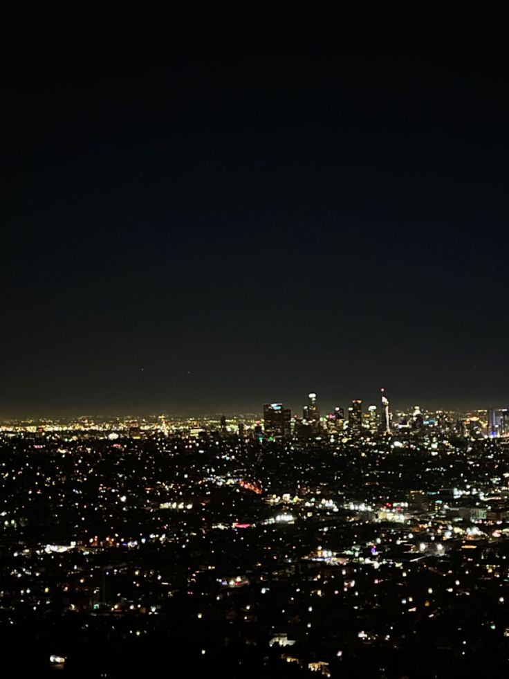 an aerial view of the city lights at night from high up in the sky with no clouds