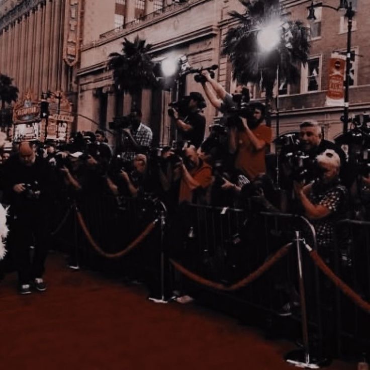 a crowd of people standing on top of a red carpet