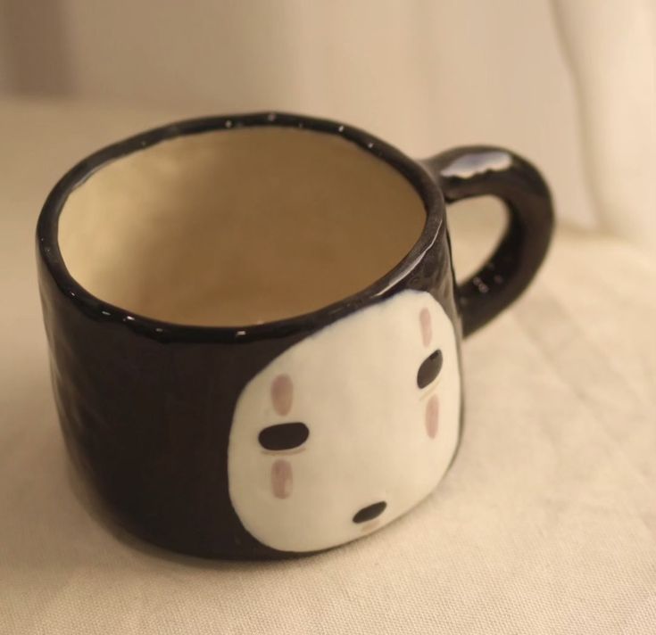 a black and white coffee cup sitting on top of a table