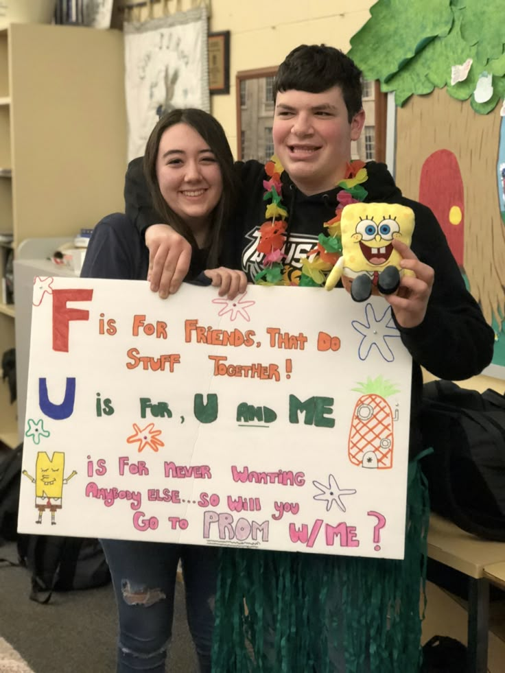 two people standing next to each other holding up a sign