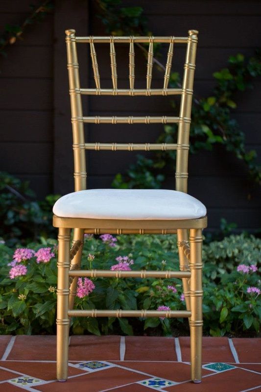 a gold chiavar chair with a white cushion