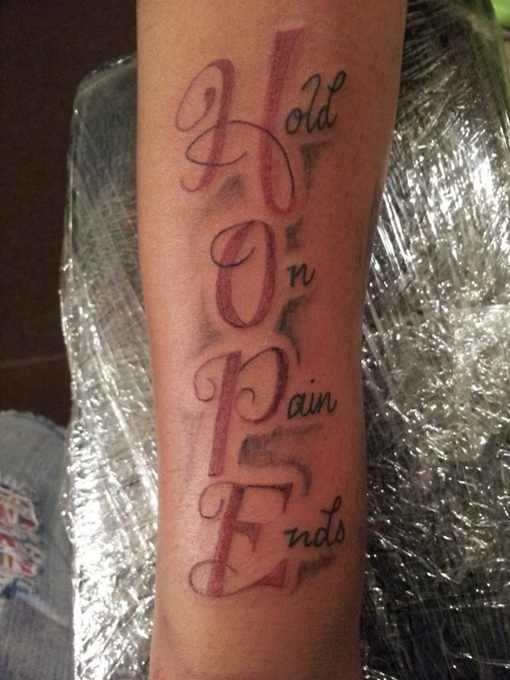 a person with a tattoo on their leg that says hope in latin and english letters