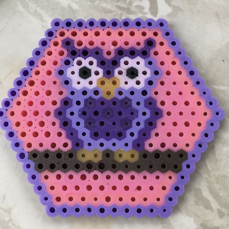 a purple and pink owl made out of perler beads