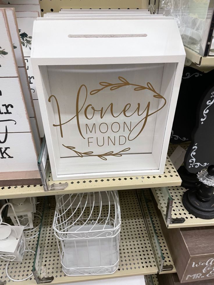 a sign that says honey moon fund sitting on top of a shelf in a store