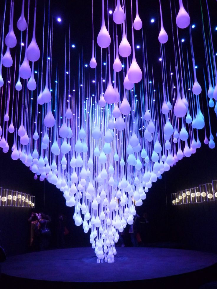 a large chandelier hanging from the ceiling in a dark room with blue lighting