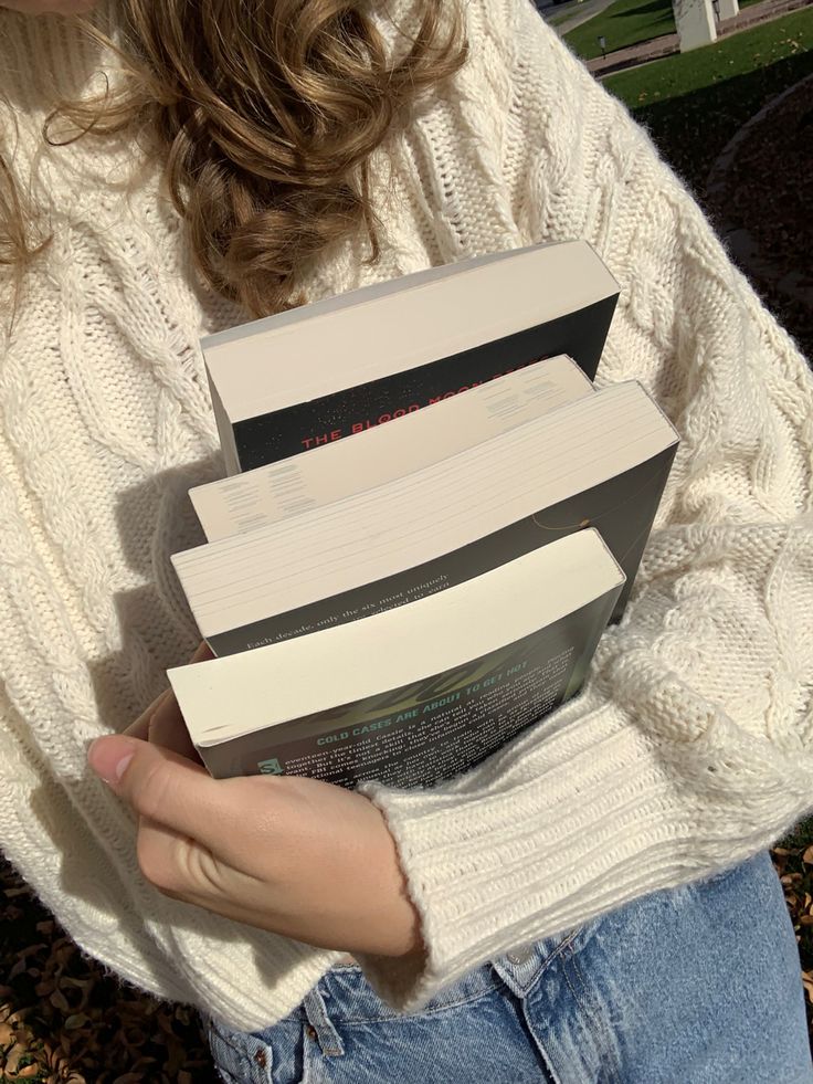 a woman holding three boxes in her hands