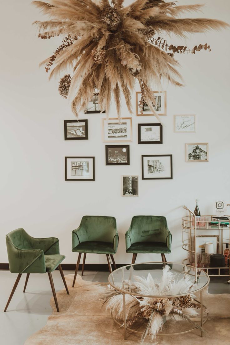 a living room with green chairs and pictures on the wall