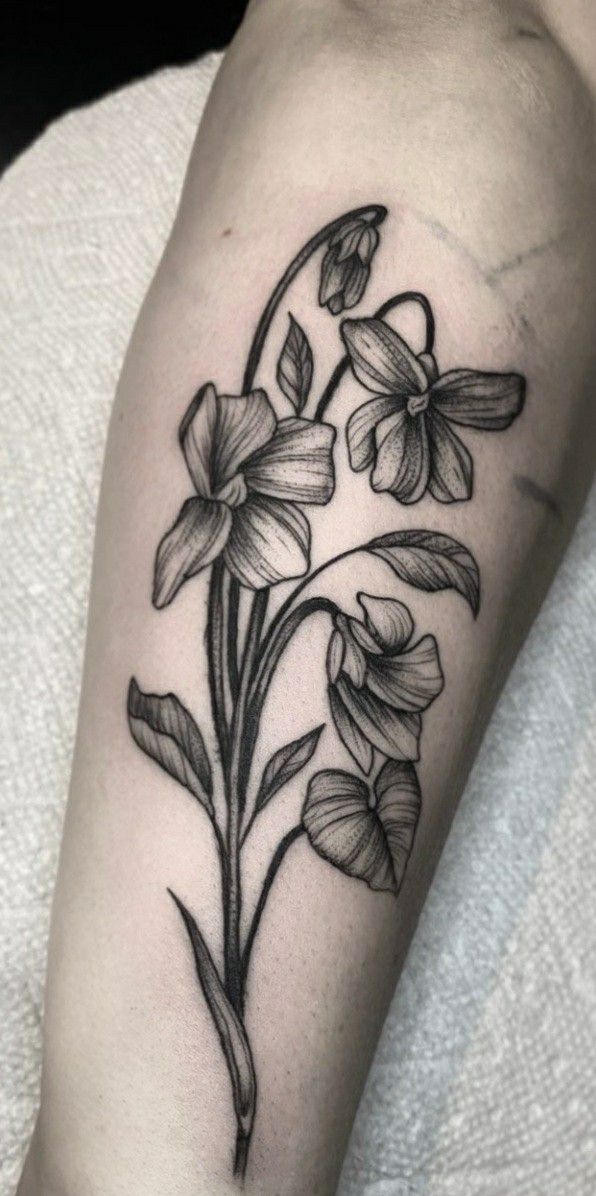 a black and white flower tattoo on the arm