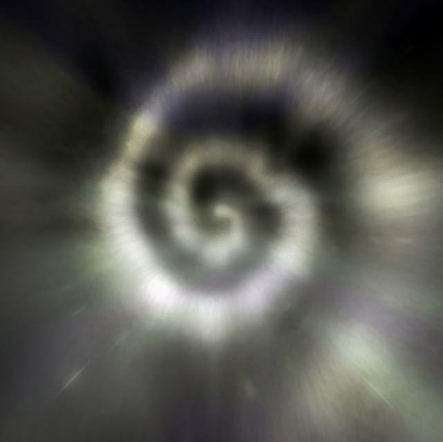 an image of a black and white spiral in the air with light coming from it