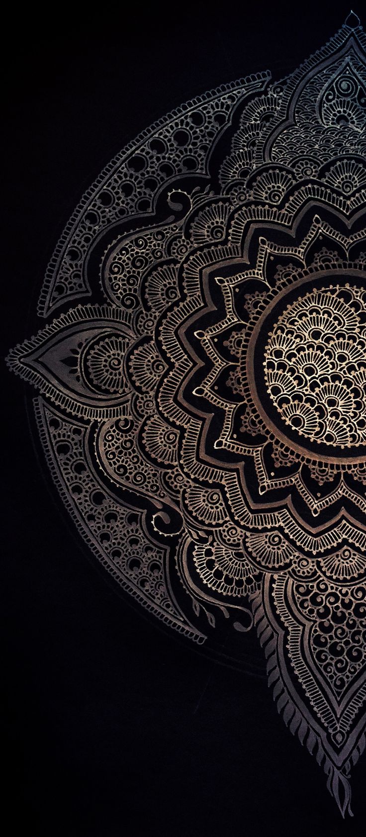 an intricately designed doily is shown in black and gold colors on a dark background