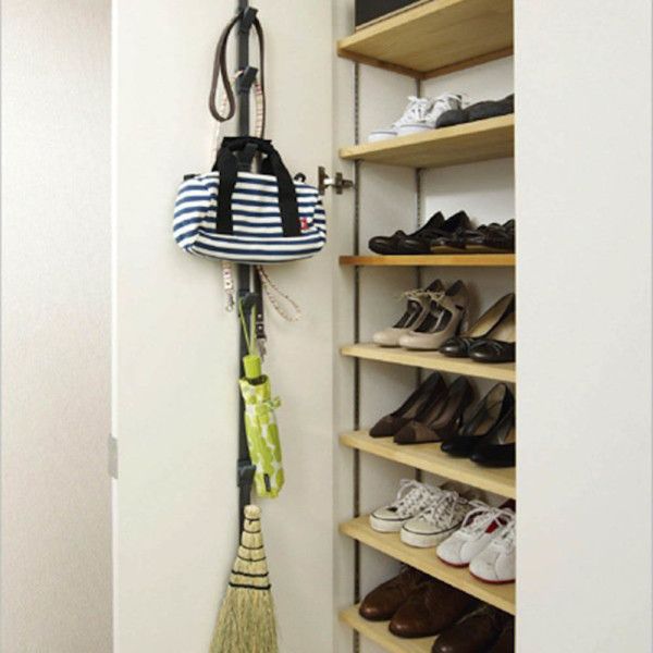 a closet with shoes and umbrellas hanging on the wall