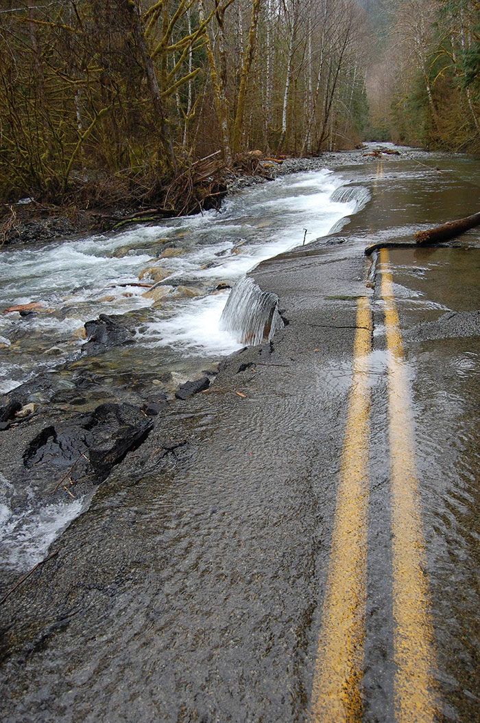 there is a yellow line on the side of the road that goes through some water