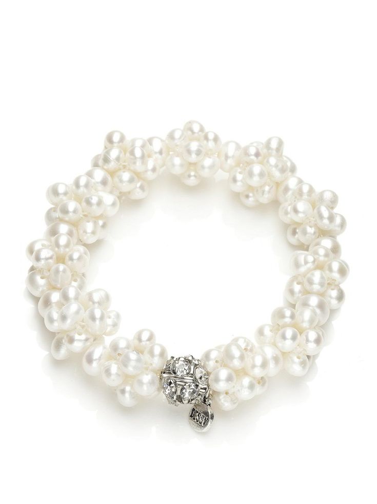 a white bracelet with pearls and a silver beaded charm on the clasp is shown