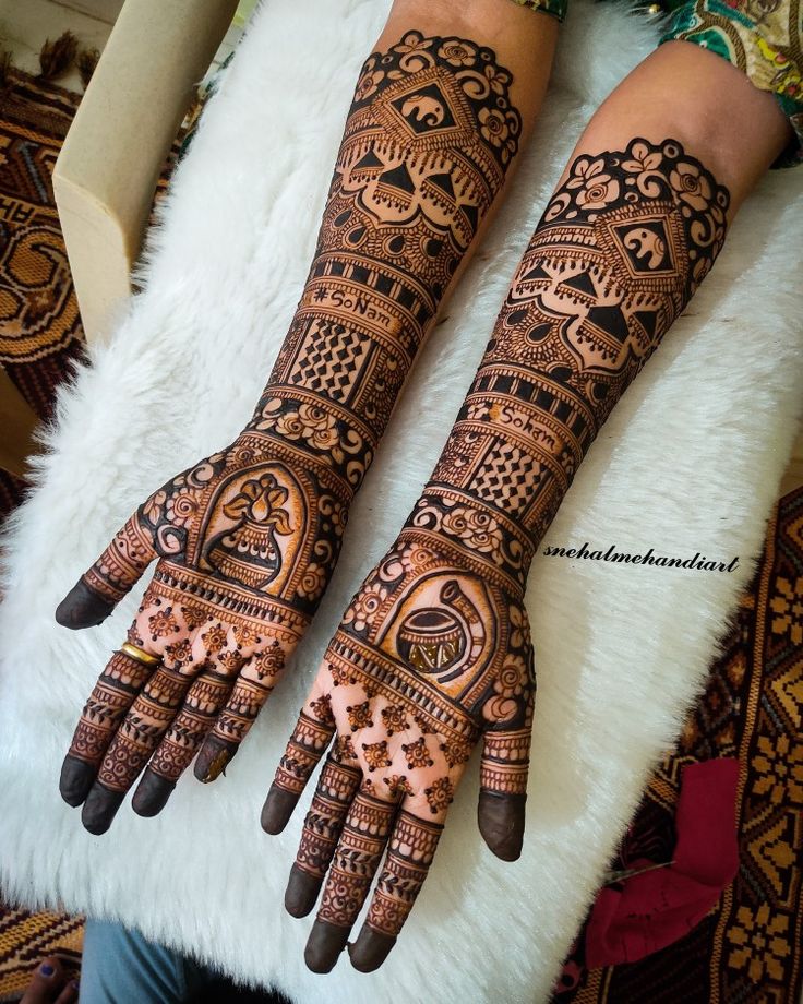 two hands with henna tattoos on them