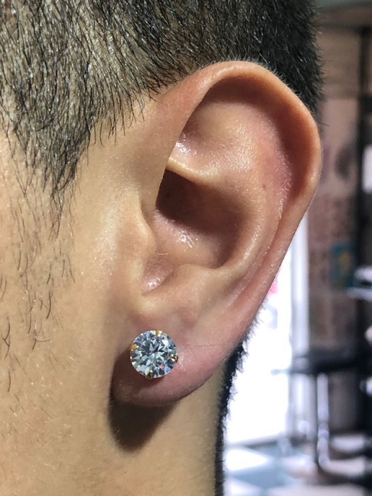 a close up of a person wearing a pair of ear piercings on their ears