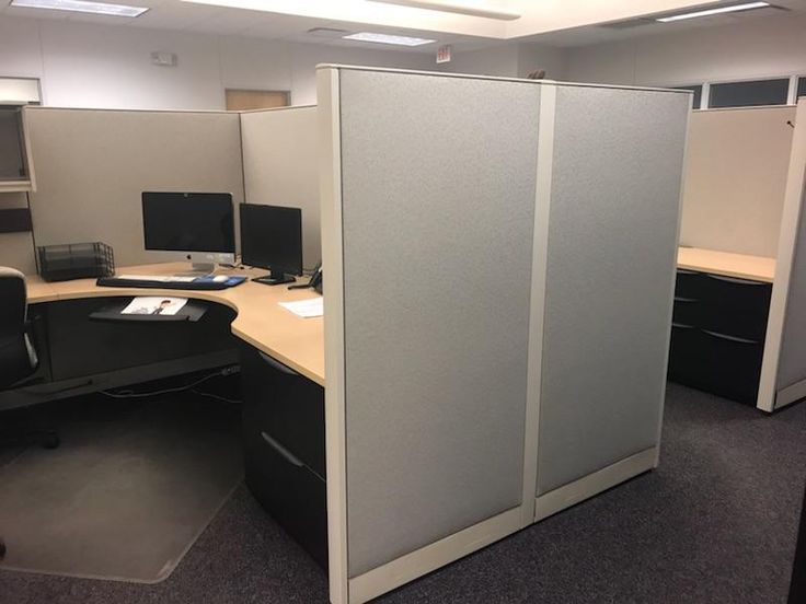 an office cubicle with sliding doors and desks in the corner, along with two computer screens