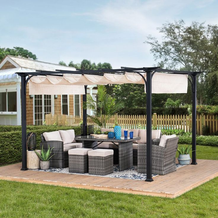 an outdoor living area with furniture and a gazebo in the middle of the yard