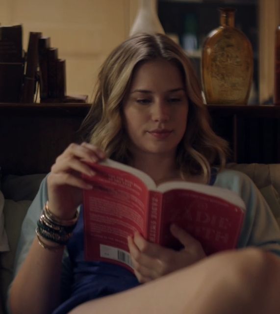 a woman sitting on a couch reading a book